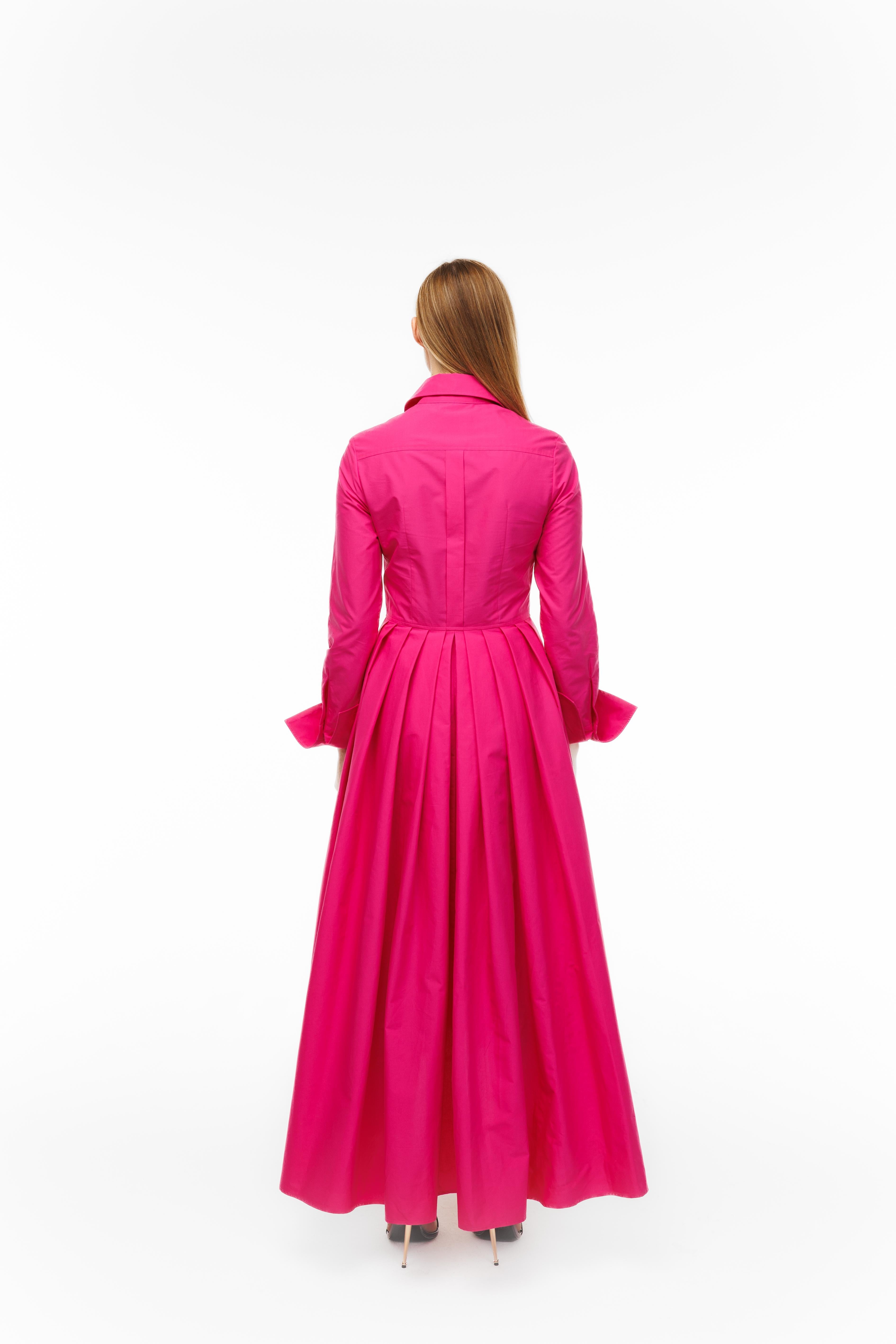 Woman wearing a long pink coat on a white background