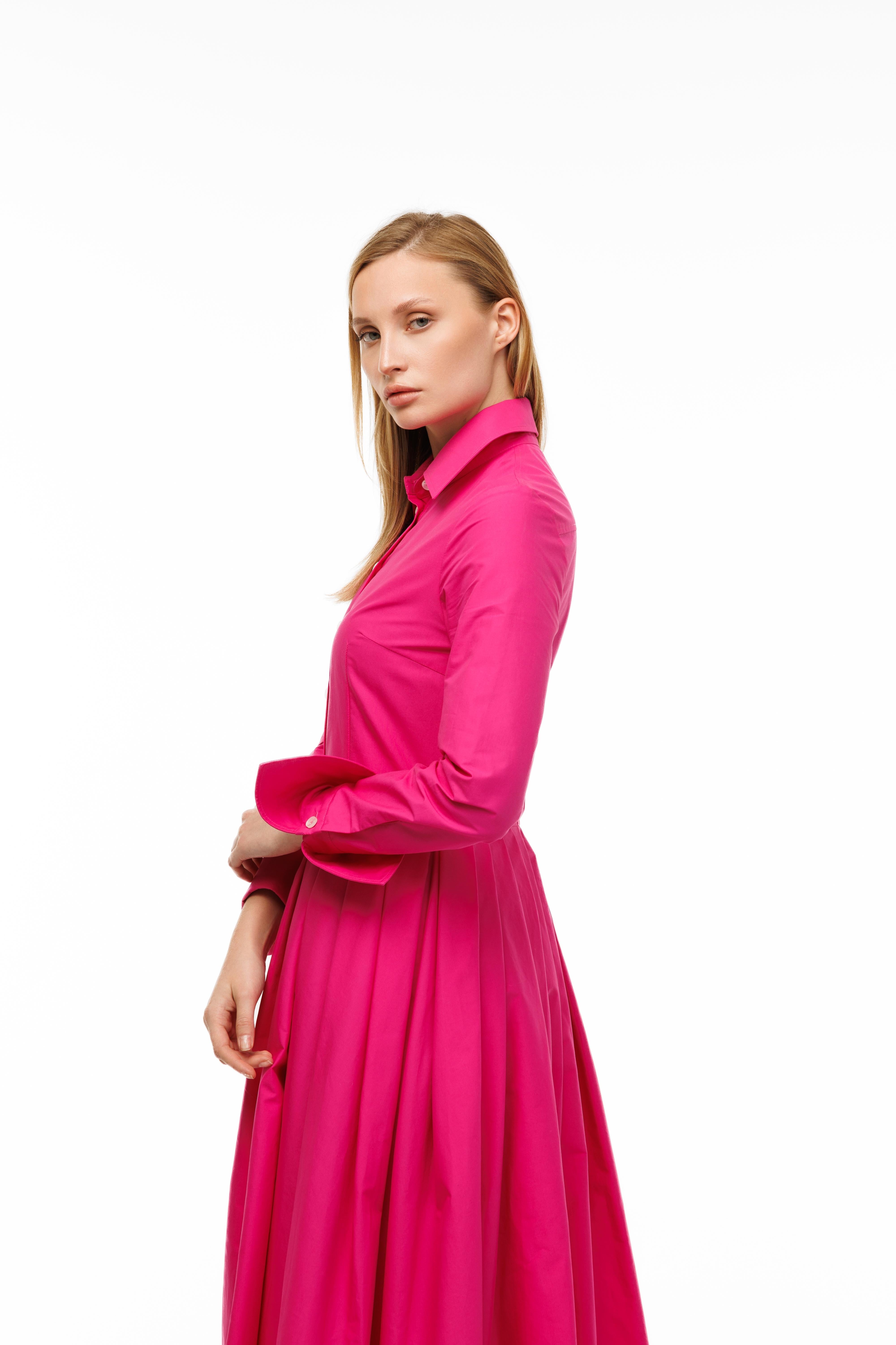 Woman wearing a bright pink dress on a white background