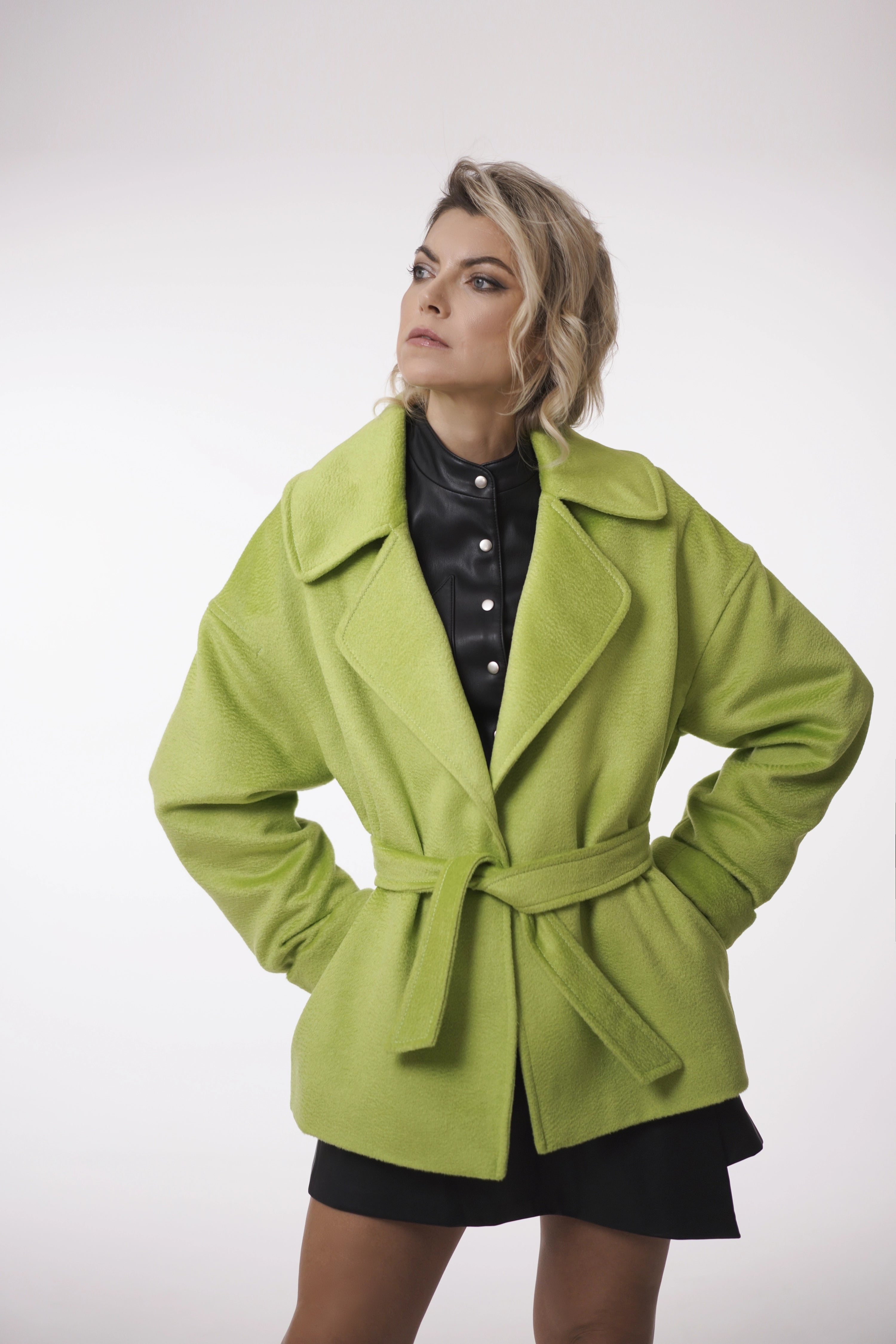 Woman wearing Spring Touch Coat from Mimaussy Paris, bright green coat shown front view on white background, studio setting