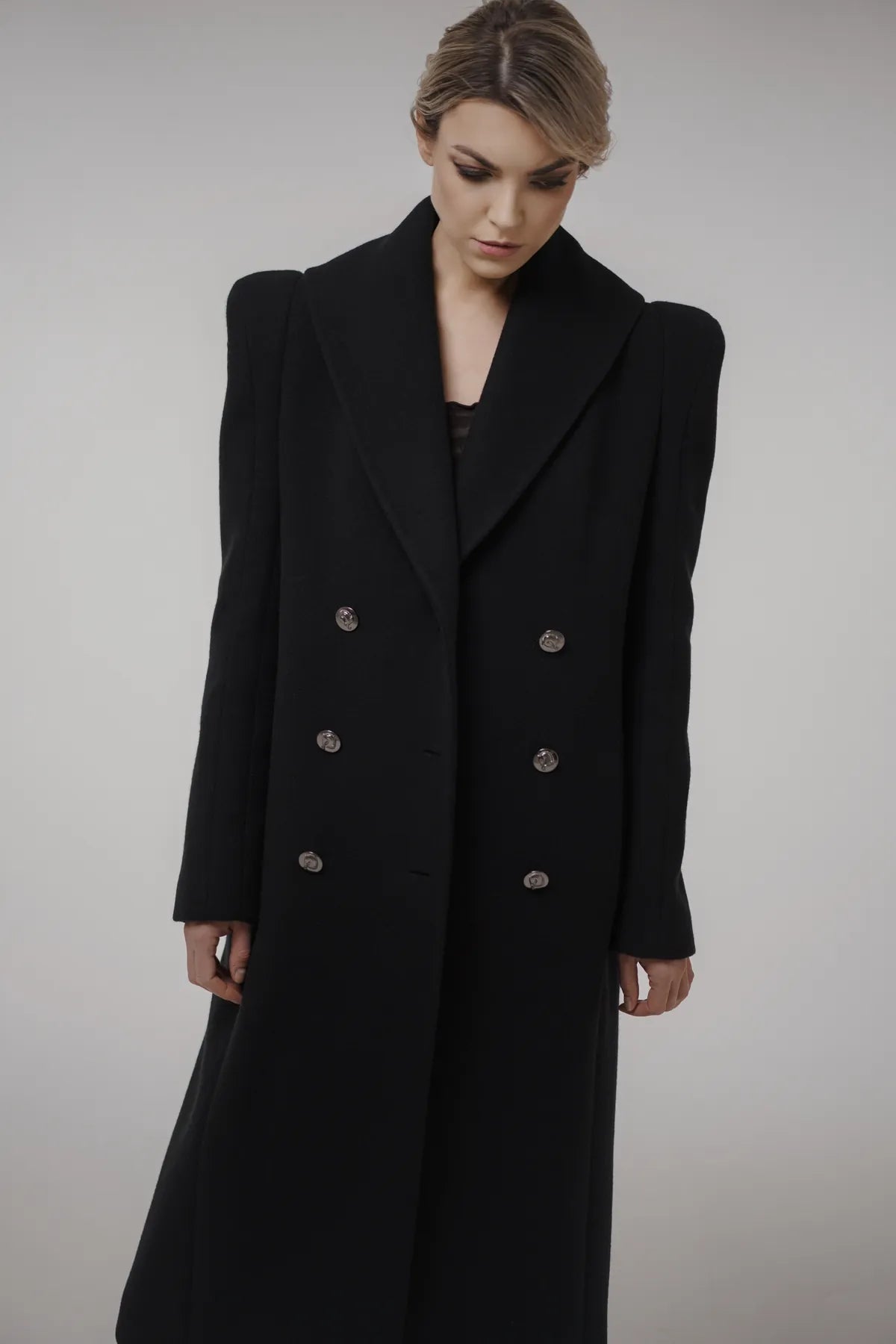 Woman wearing a black The Griffons Coat with silver buttons by Mimaussy Paris
