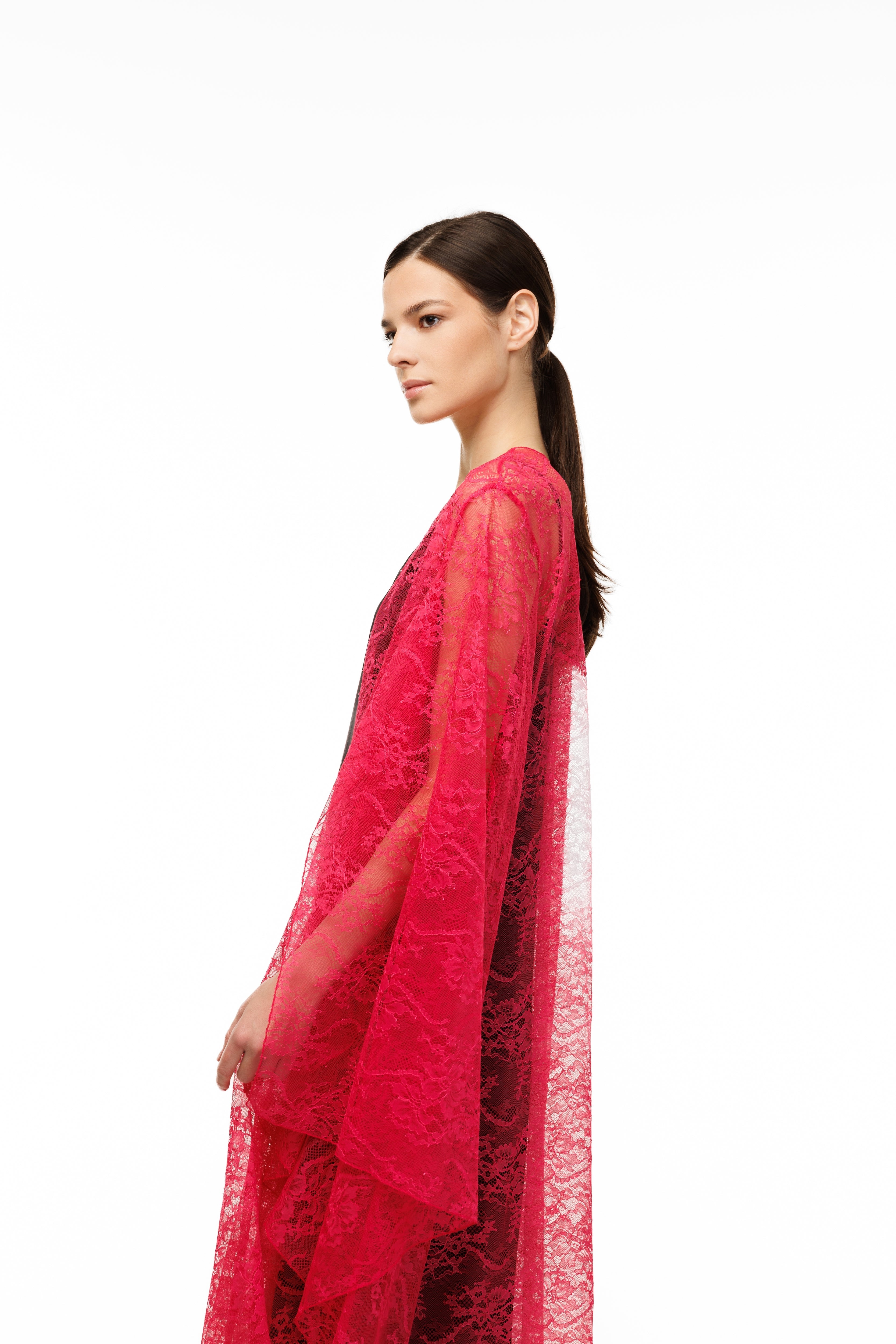Woman wearing a red lace cape over a black dress on a white background