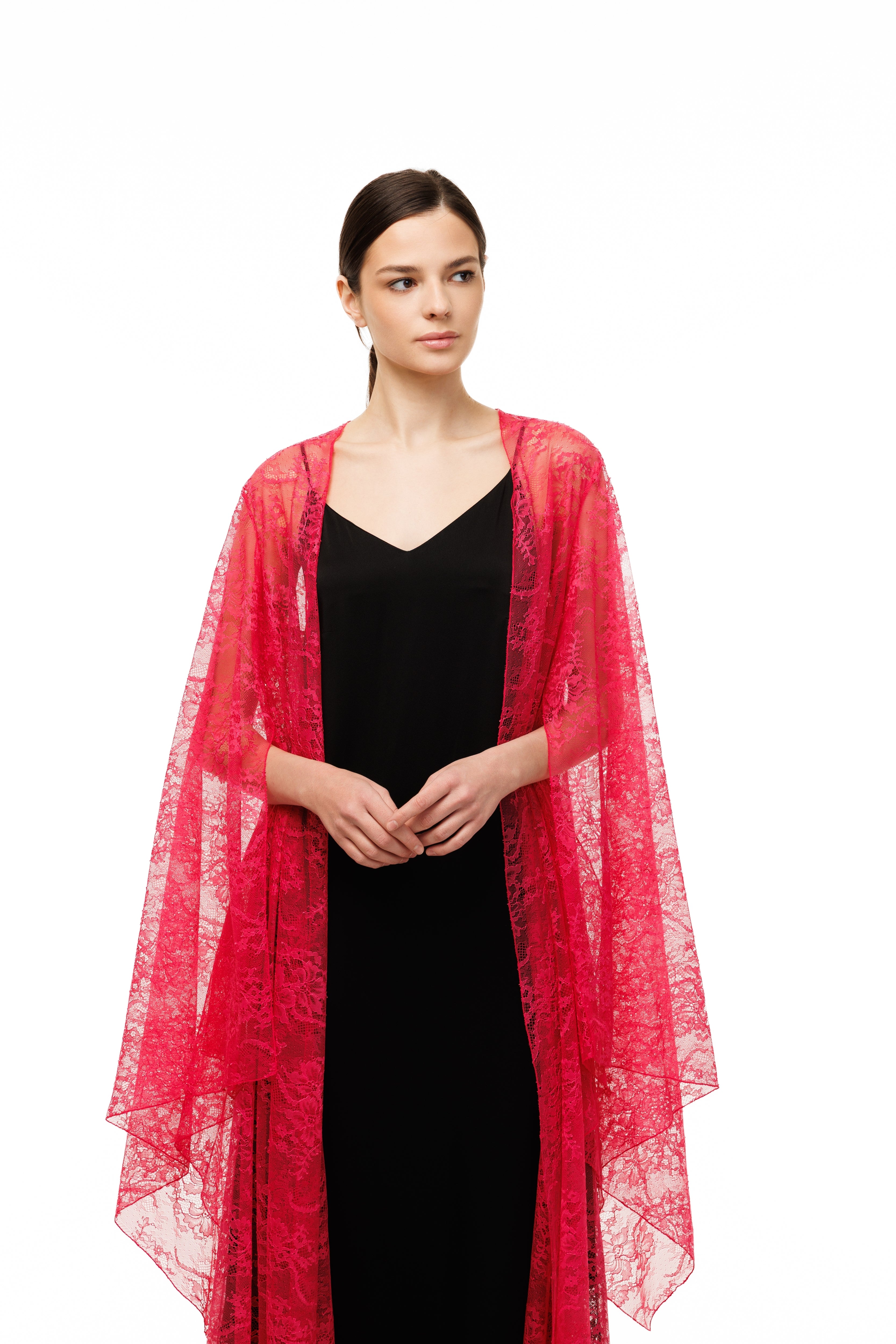 Woman wearing a red lace shawl over a black dress on a white background