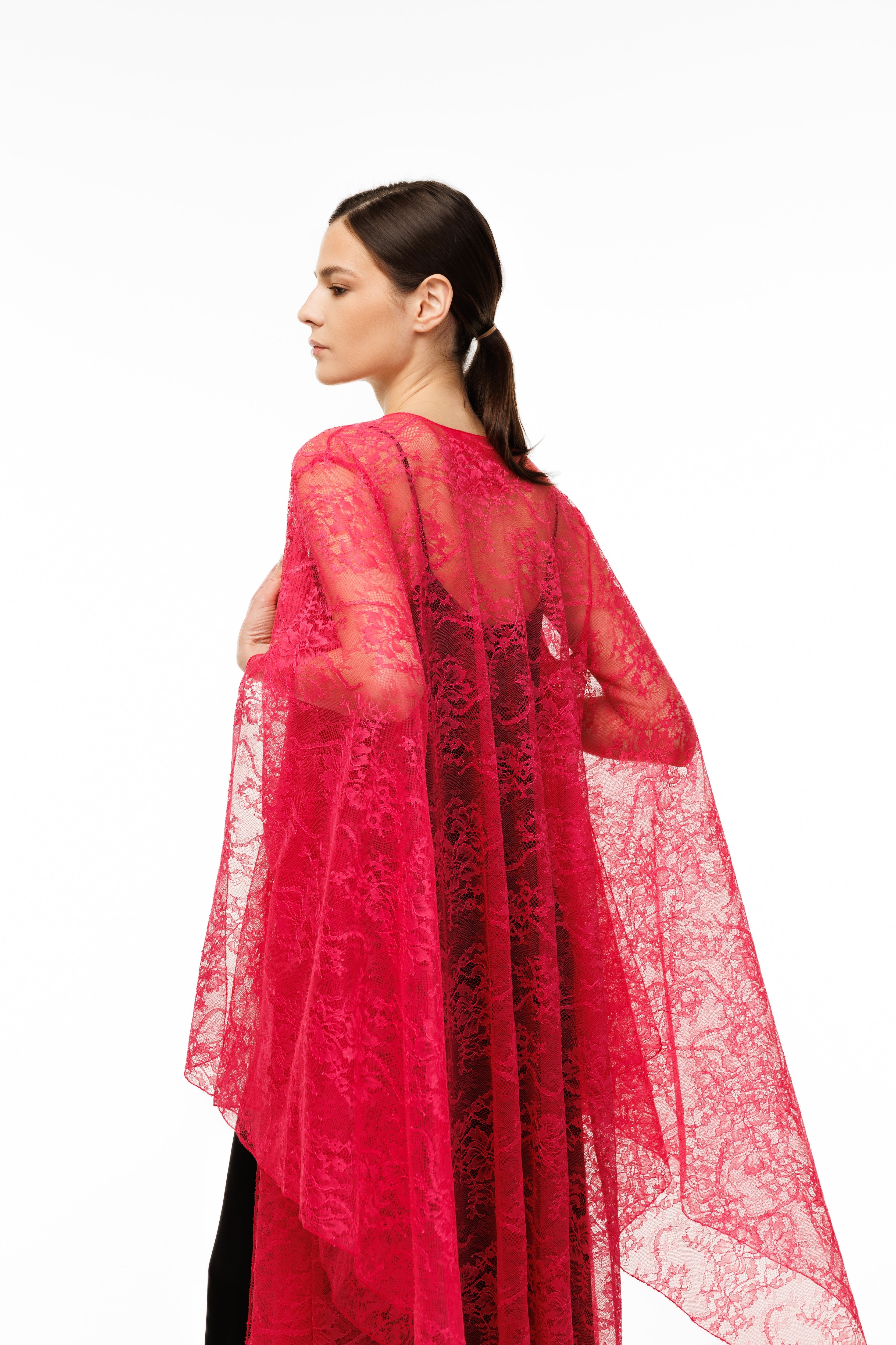 Woman wearing a red lace cape on a white background