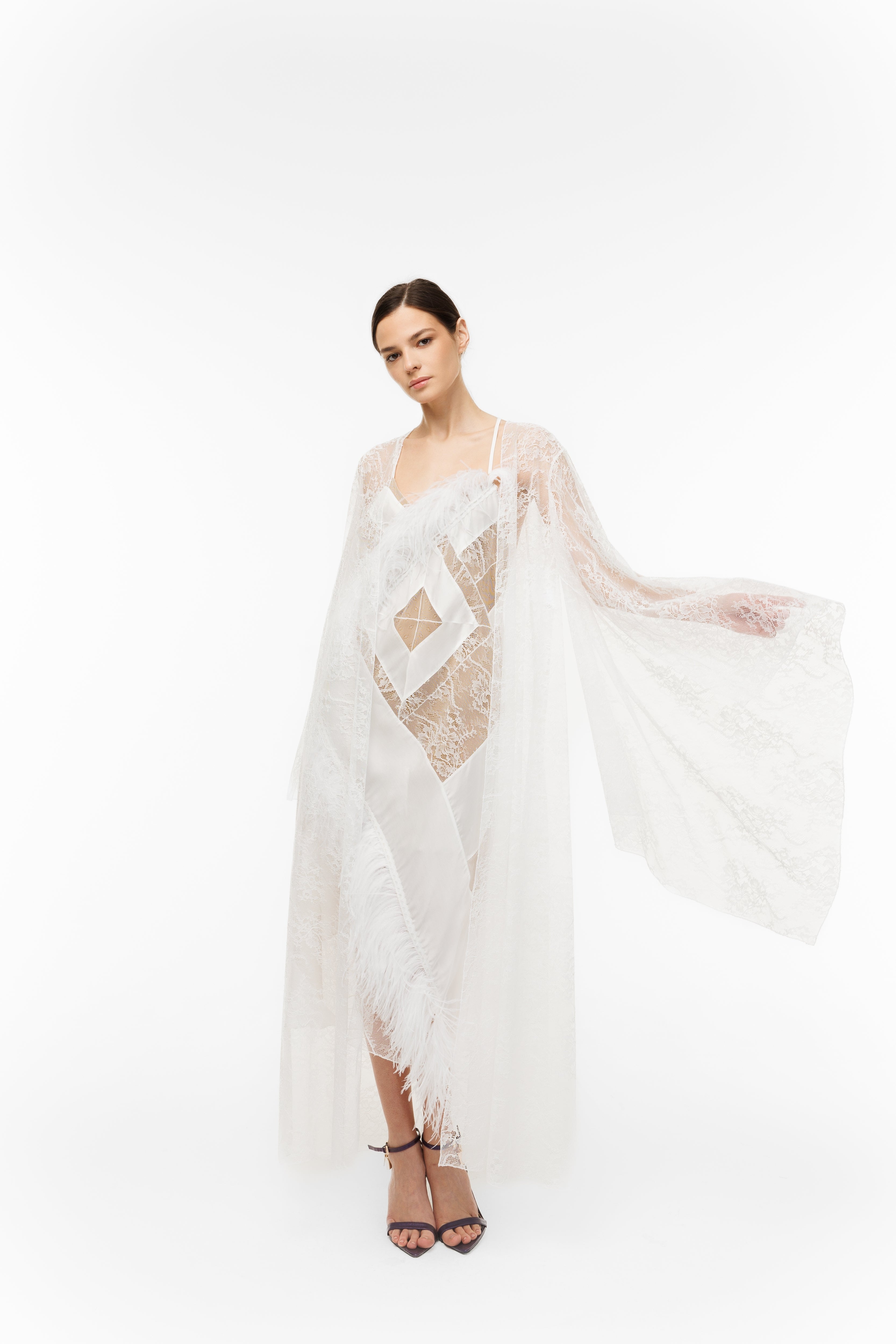 Woman wearing a white lace dress with a geometric pattern on a white background