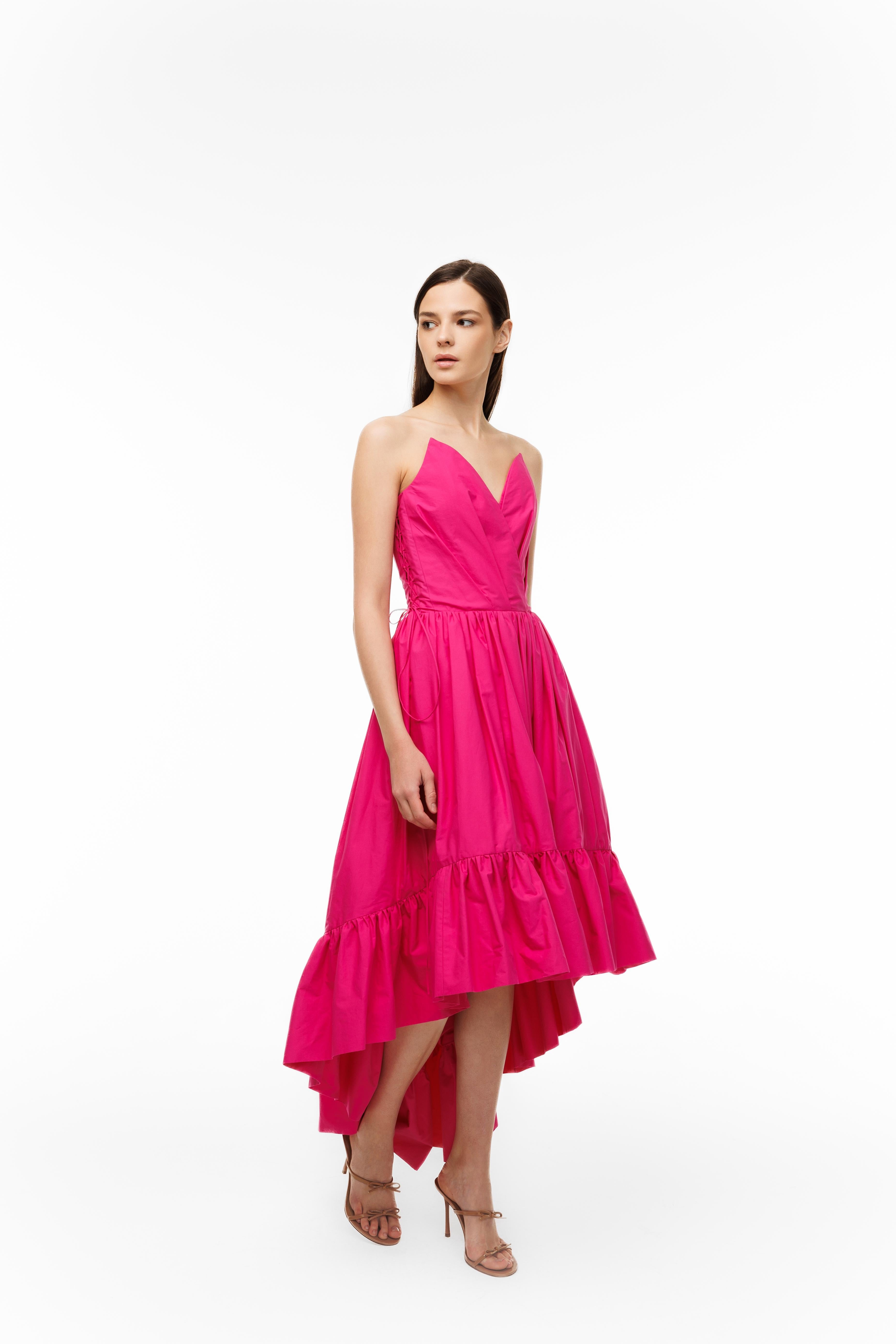 Woman wearing a bright pink dress on a white background