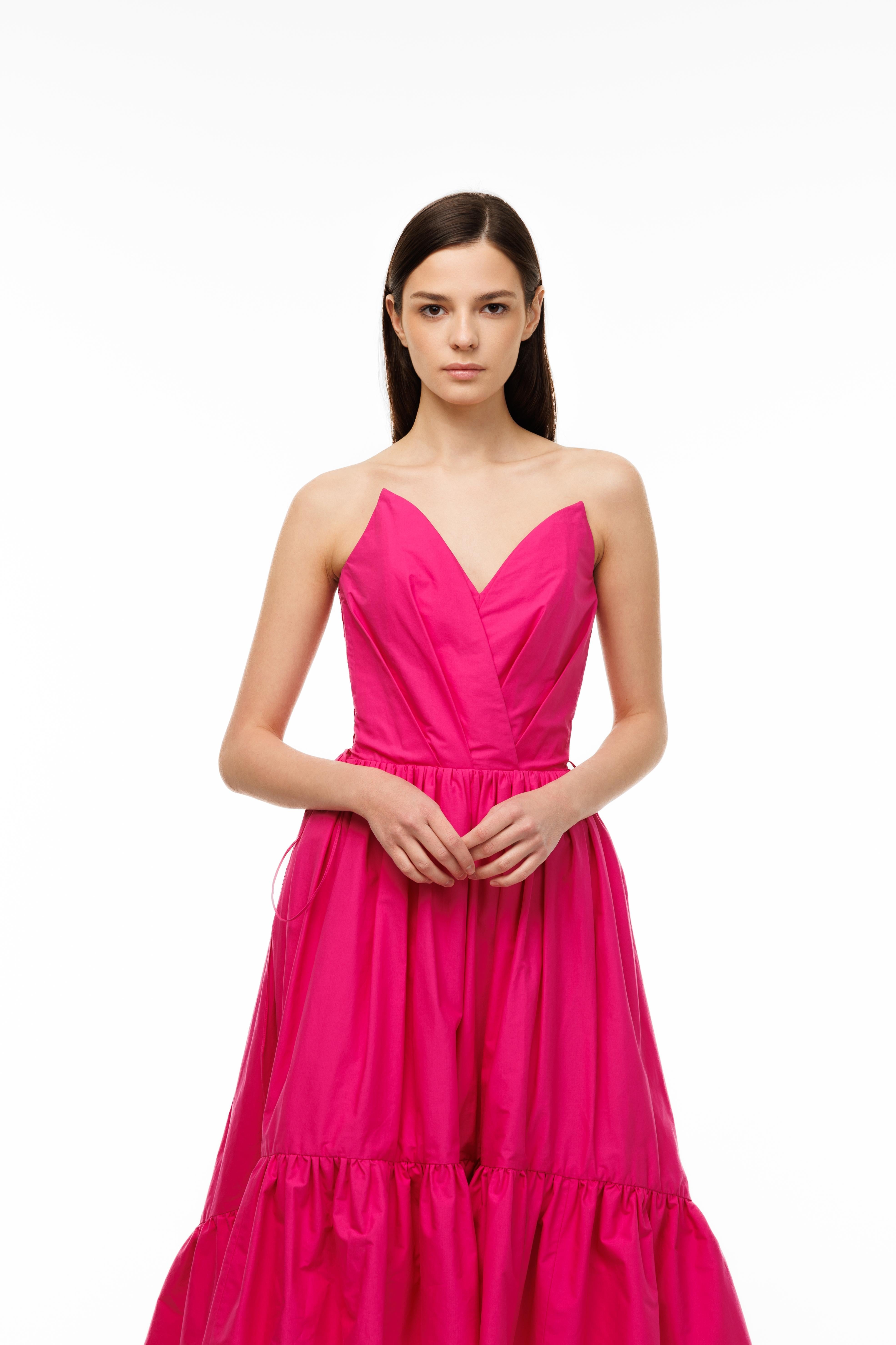 Woman wearing a pink strapless gown on a white background