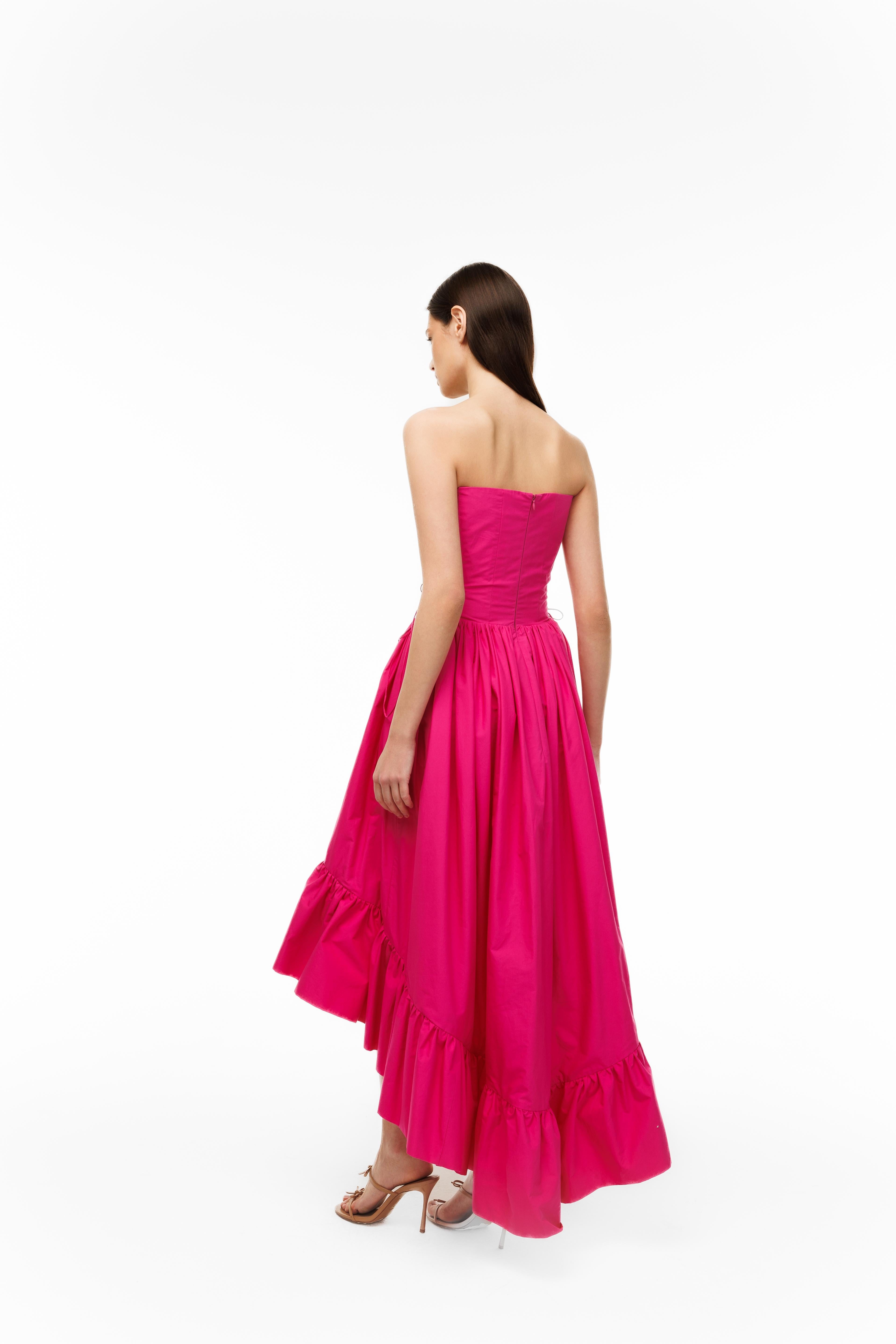 Woman wearing a pink strapless gown on a white background