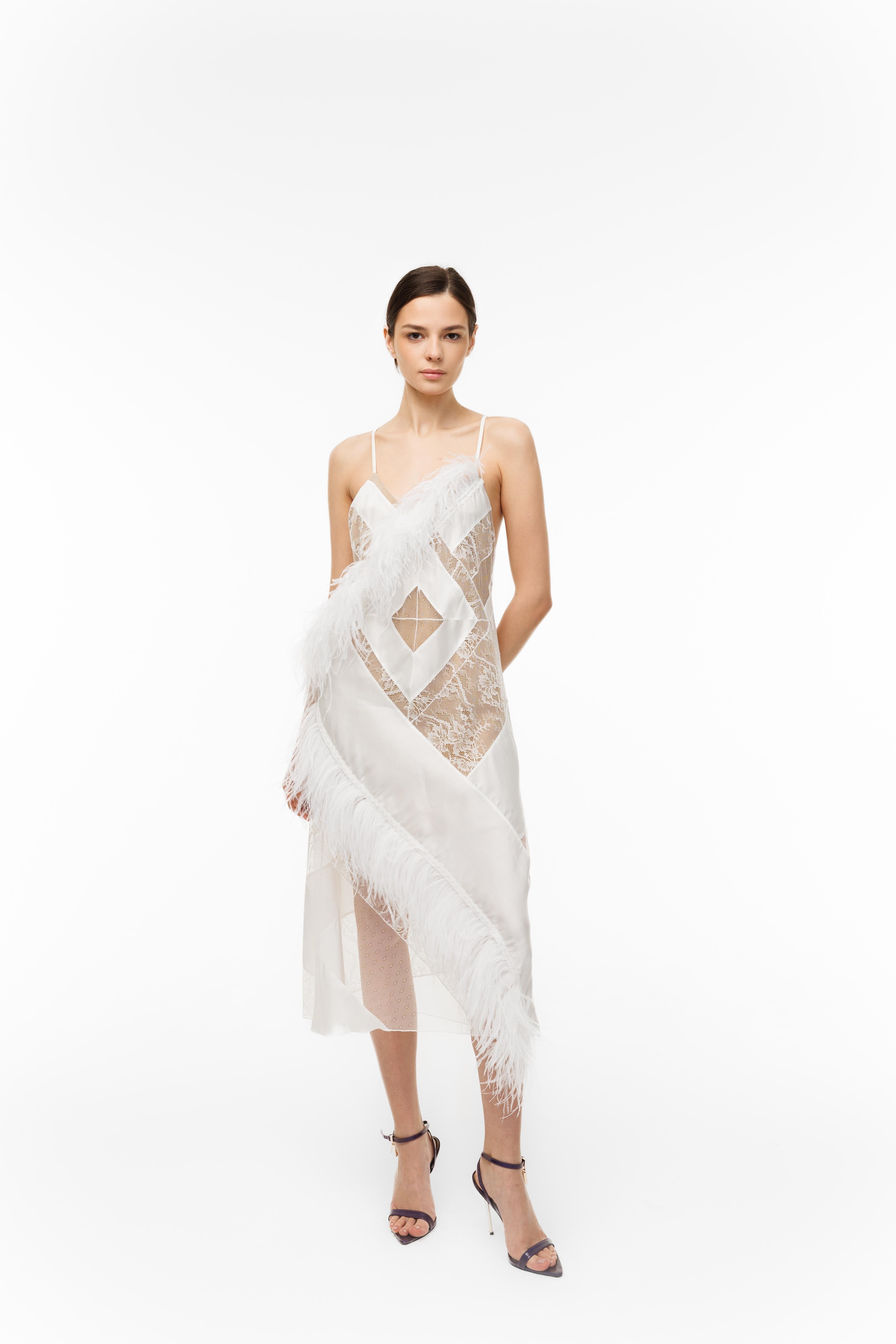 Woman wearing a white lace dress with geometric patterns on a white background