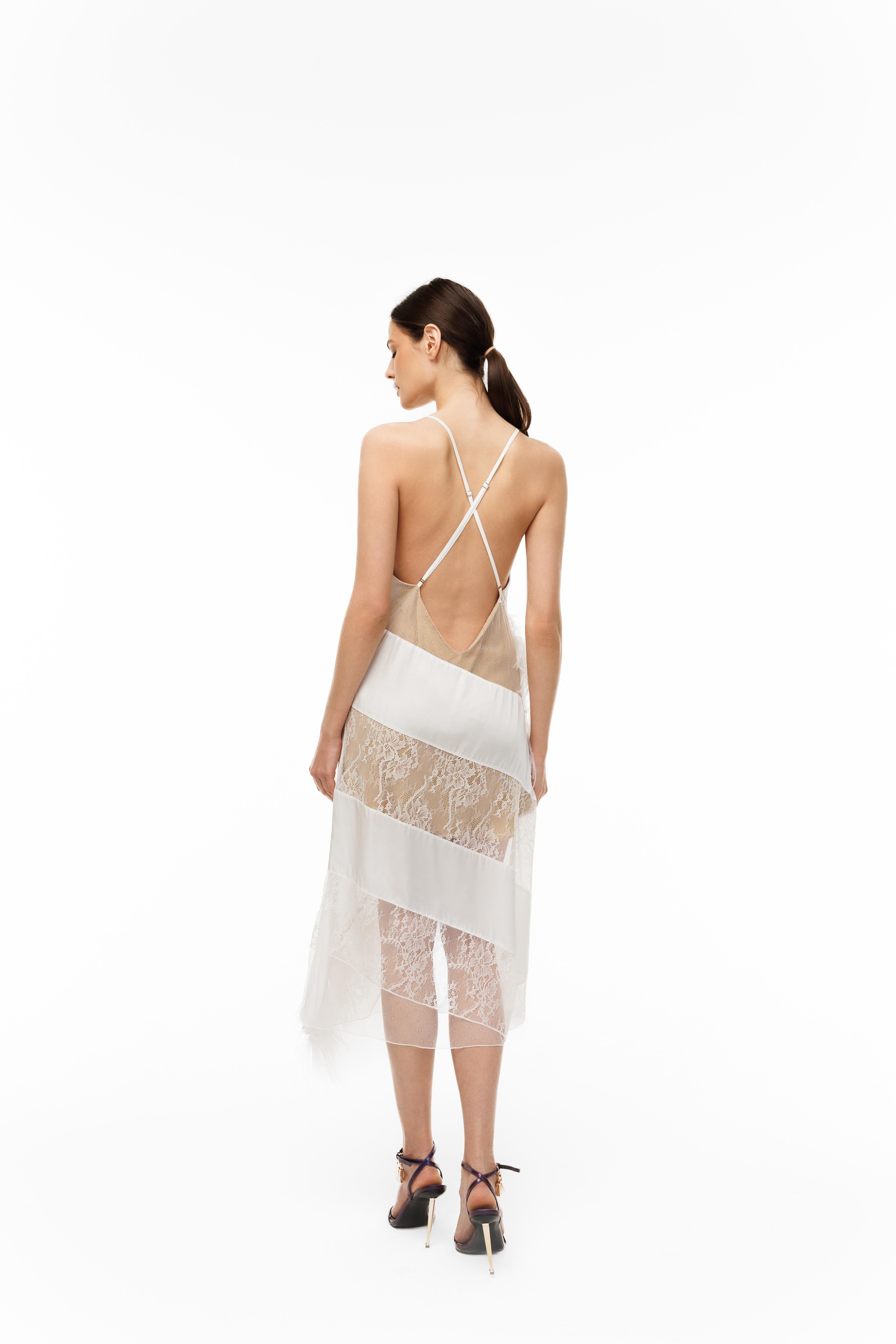 Woman wearing a white lace dress with thin straps on a white background