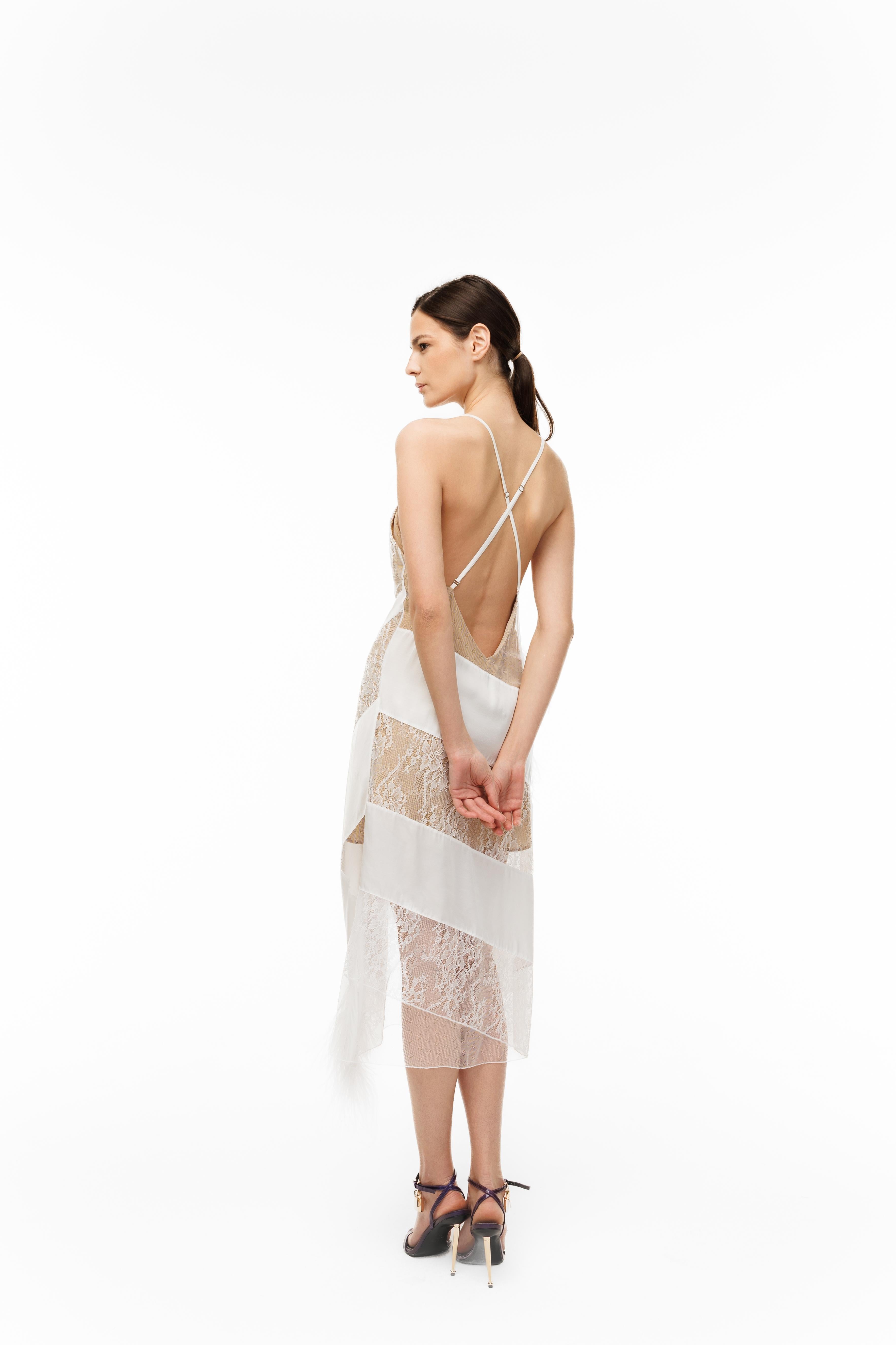 Woman wearing a white lace dress with thin straps on a white background