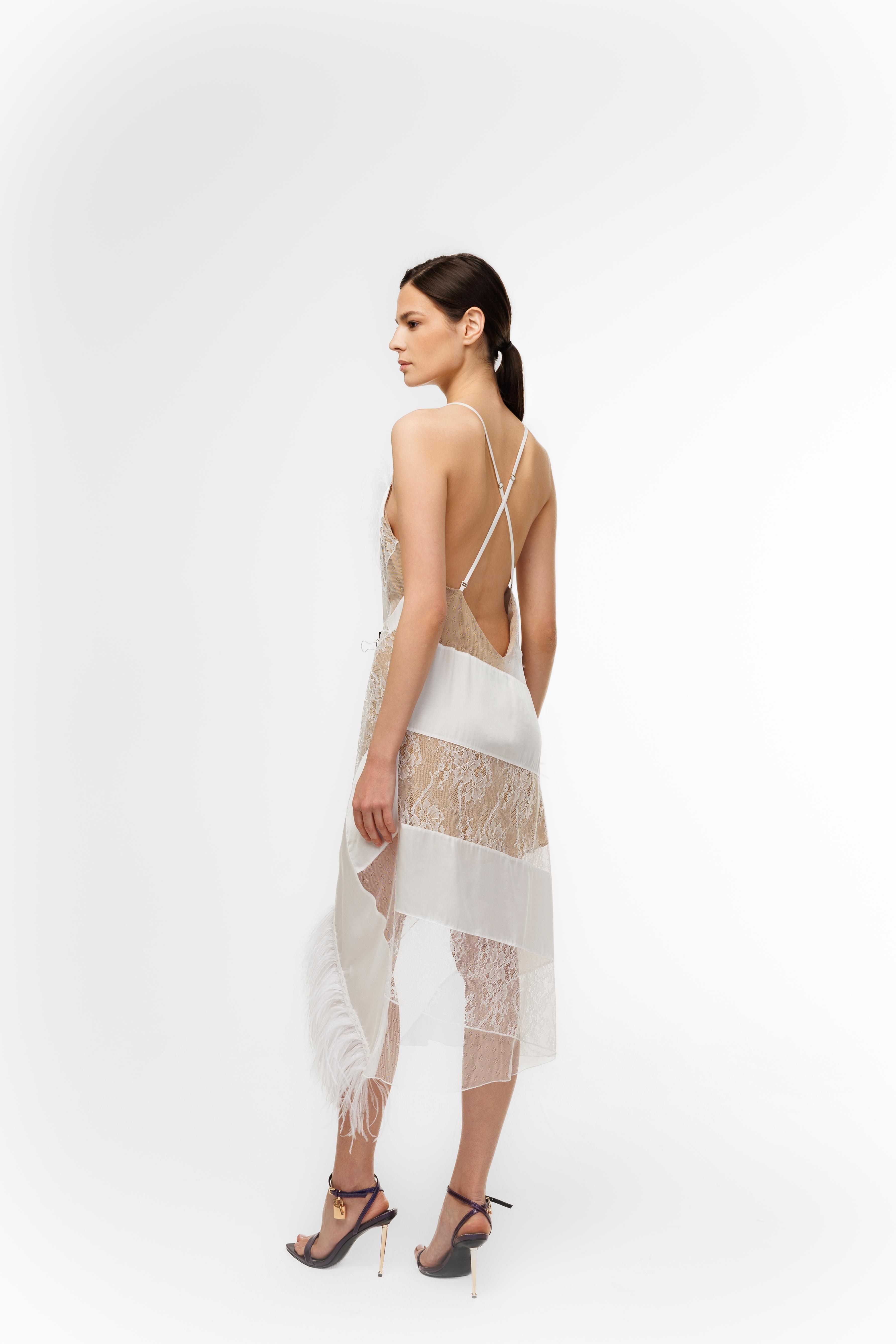Woman wearing a white lace dress with thin straps on a white background
