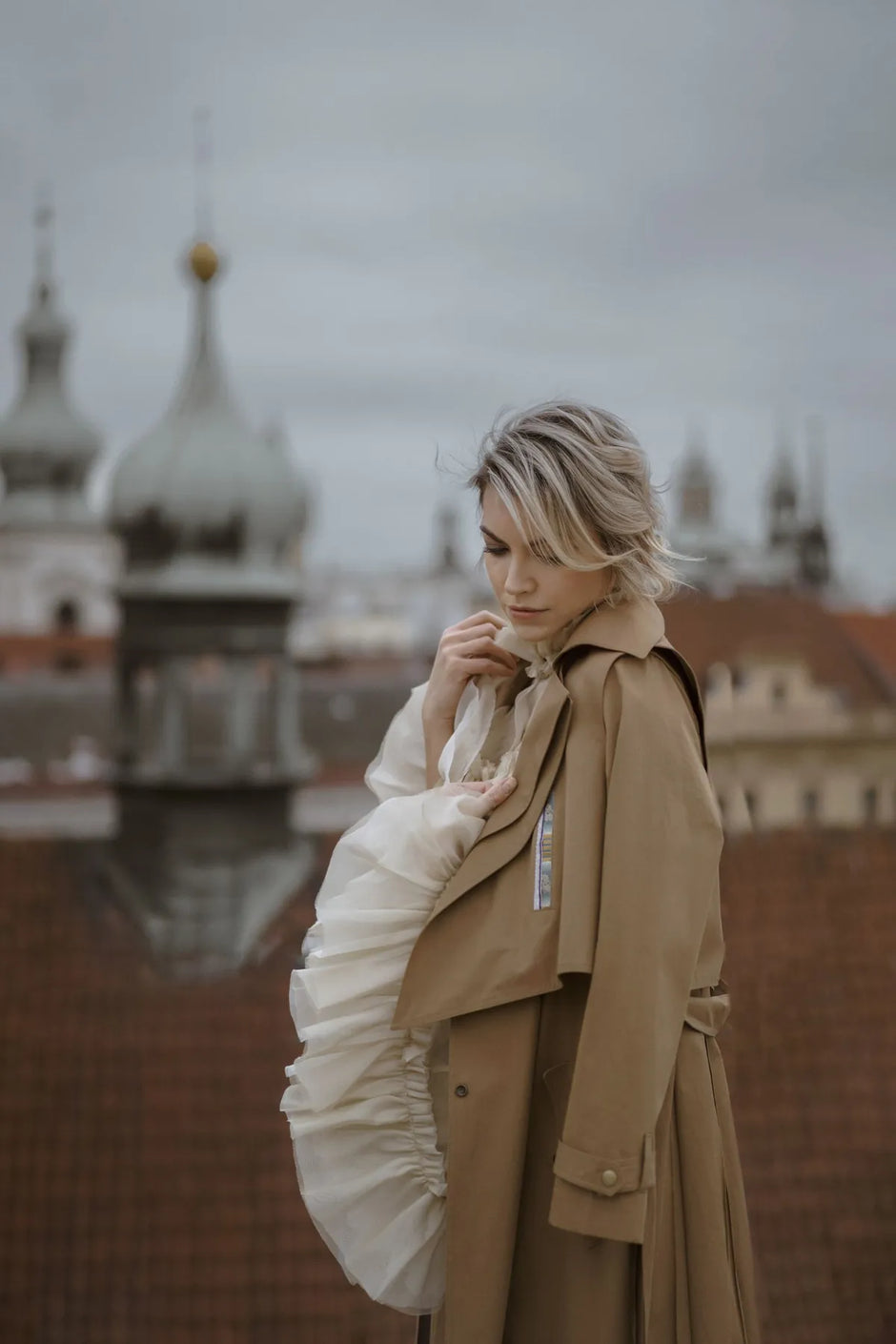 A woman models the Mimaussy Confidential trench coat over a white dress, representing Mimaussy Paris fashion.